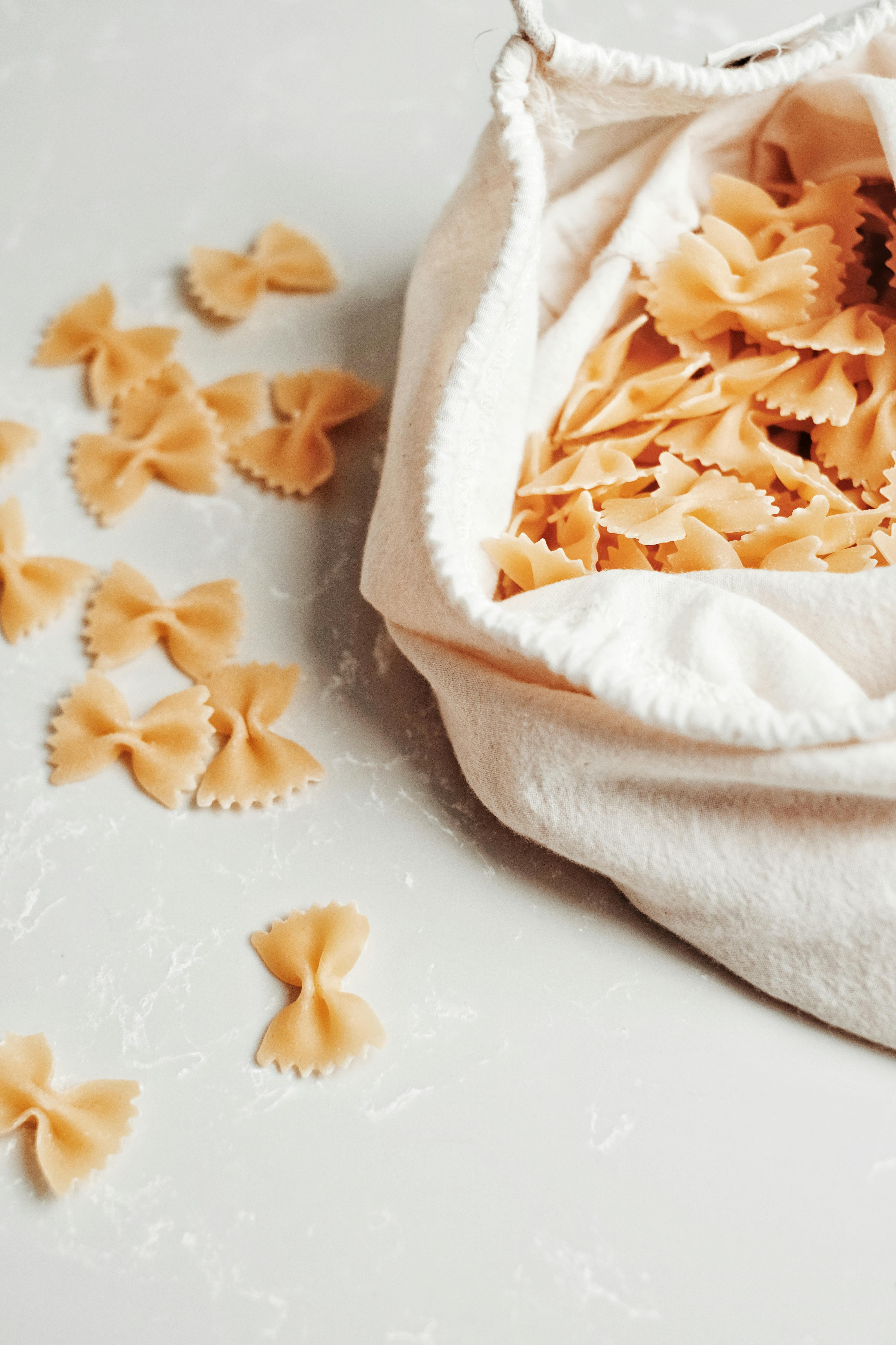 Close-up of farfalle pasta in a reusable cloth bag, highlighting sustainability.