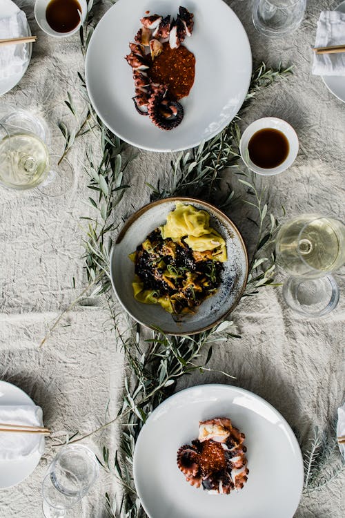 Free Plates with palatable dishes and glasses of wine Stock Photo