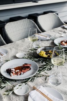 From above of table with tasty food and glasses of wine served for guests