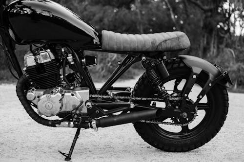 Black and white of modern metal motorcycle parked on road against blurred background