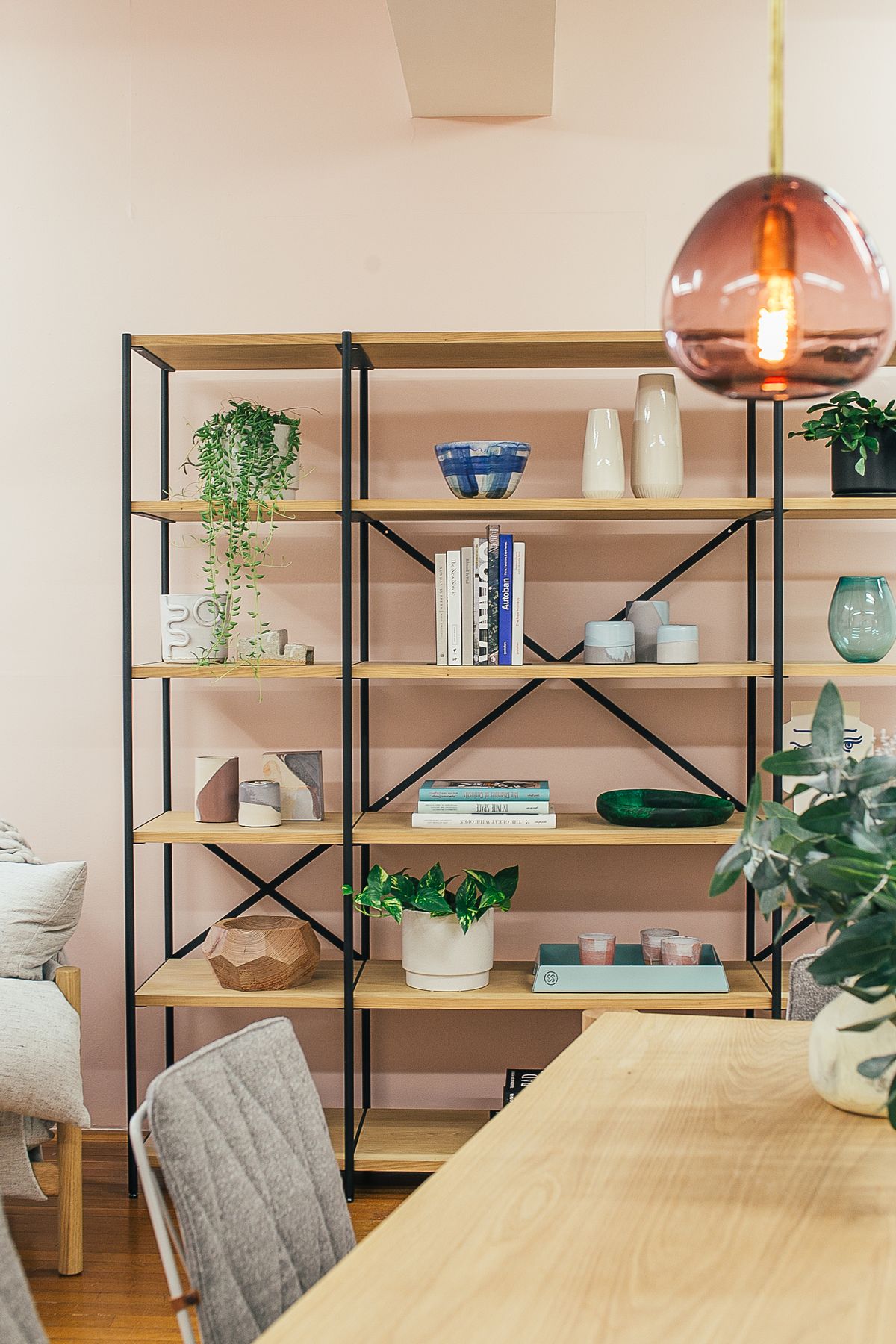 Décoration d'étagères avec plantes, livres et objets décoratifs dans un salon cosy