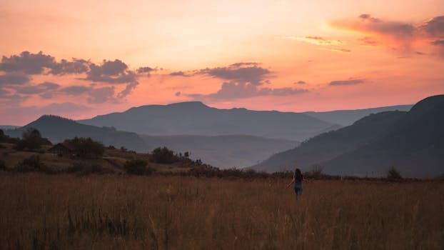 在南非的山脉上，一个人享受着宁静的风景，欣赏着令人惊叹的日落