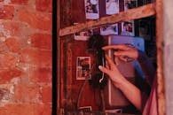 红砖公共电话亭里，使用老式电话的双手特写，唤起怀旧之情