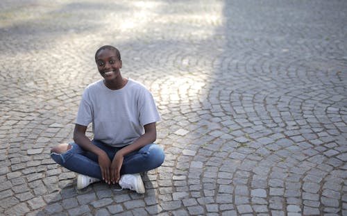 A Woman Smiling While Sitting on the Floor 