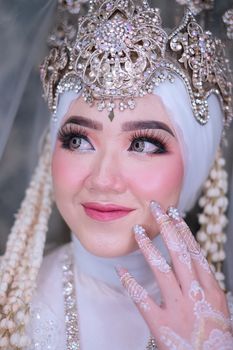 Close-up portrait of a bride in traditional attire with intricate headpiece and makeup.