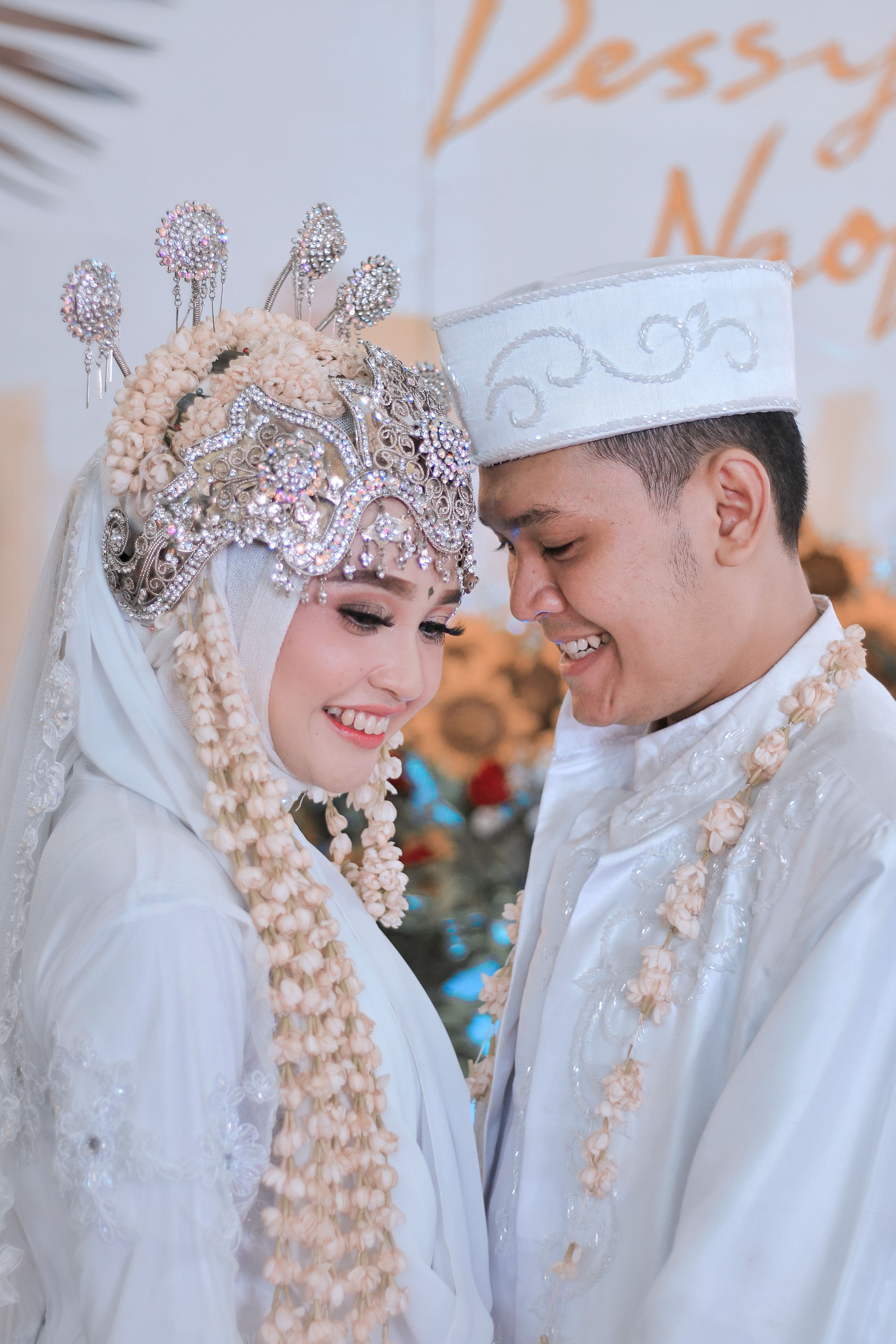 A joyful couple celebrates their wedding day in stunning traditional attire, showcasing cultural elegance.