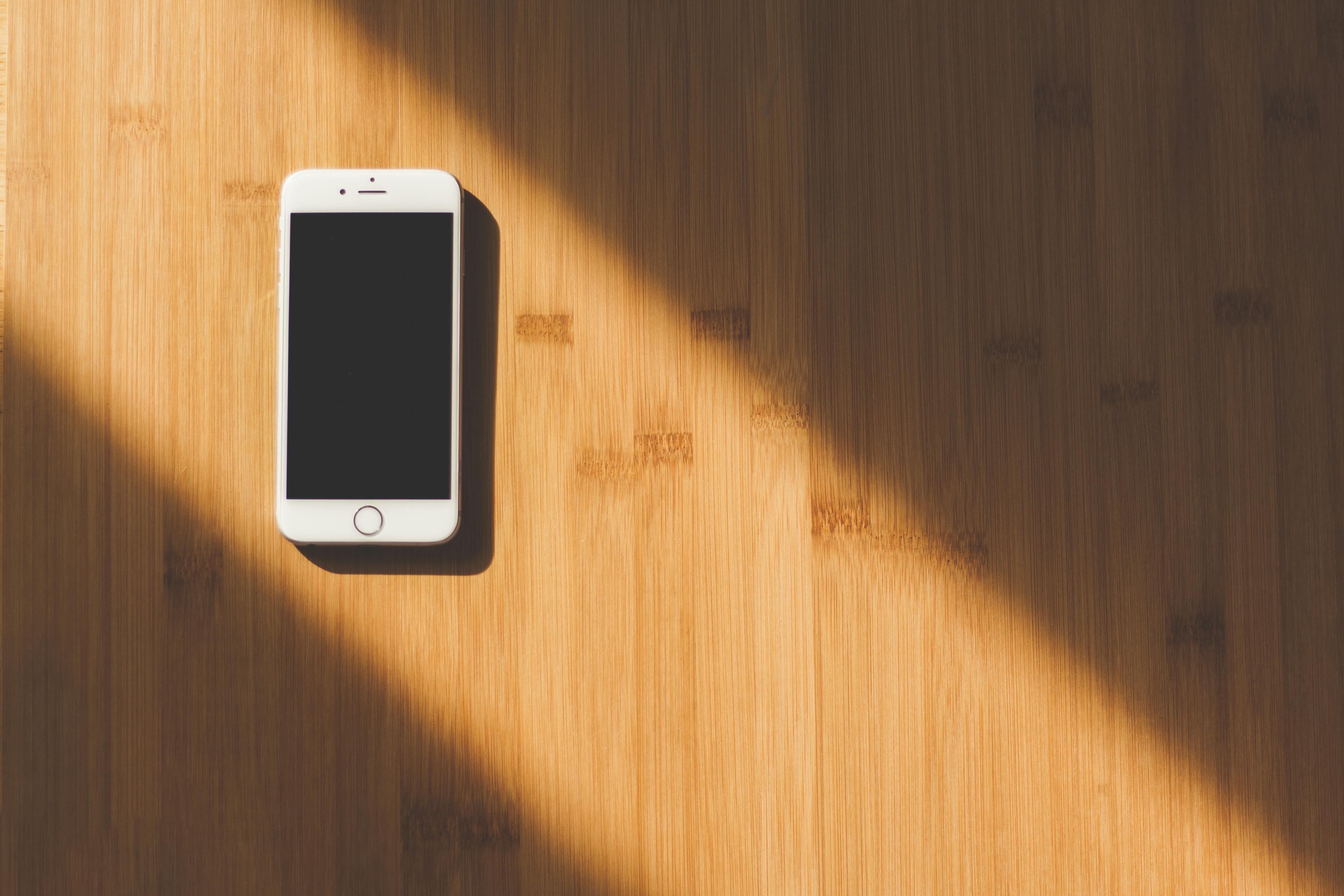 Foto stok gratis tentang handphone, iphone, meja kayu
