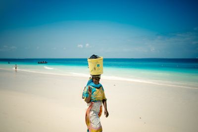 Woman walking along the Zanzibar seashore