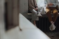 两个大人坐在窗前聊天，在室内享受休闲时光