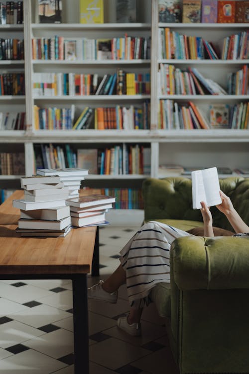 人在棕色的木桌上看書