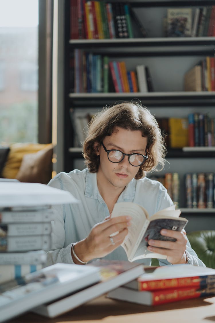 A Diligent Male Student Reading A Book