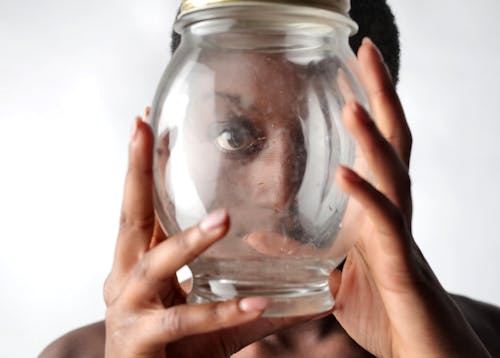 Woman Peeking Through Glass Container