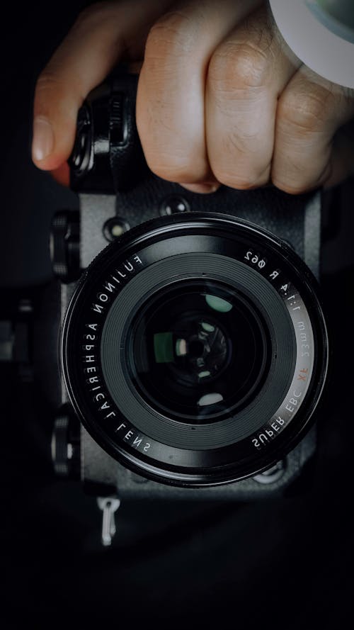 Person Holding Black Camera Lens