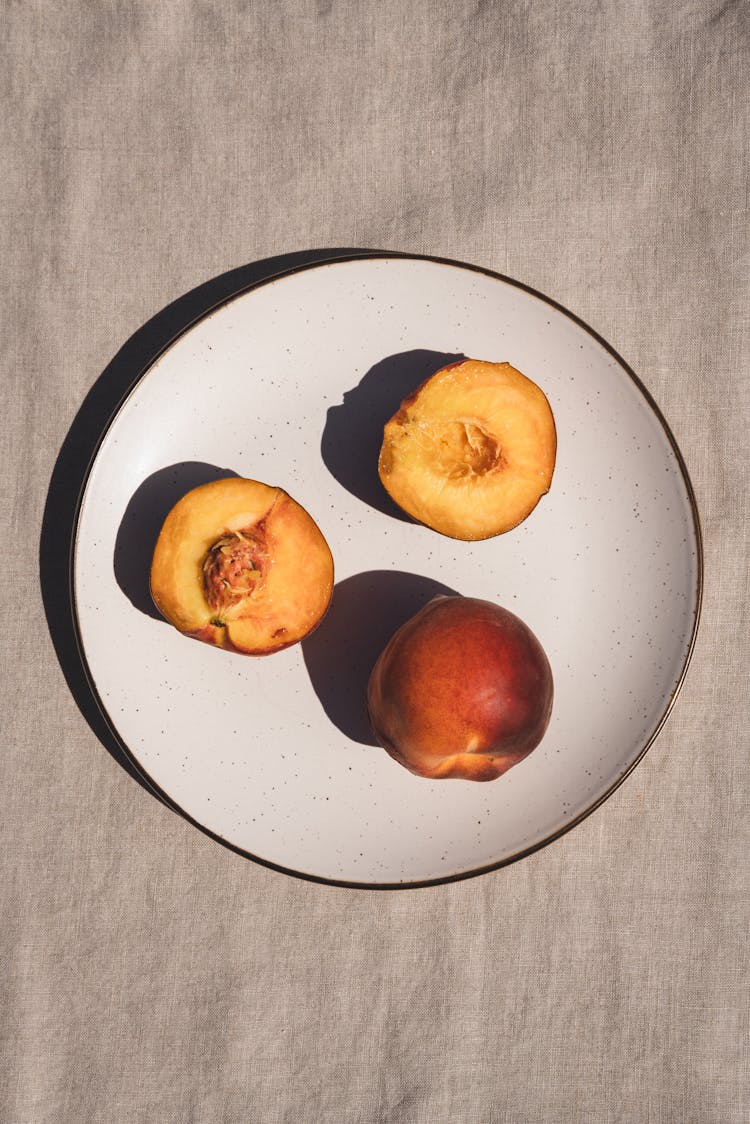 Overhead Shot Of Peaches On A White Plat