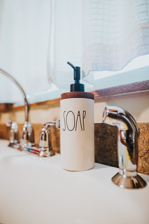 Ceramic soap dispenser placed on wash basin