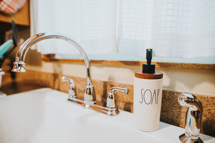 Liquid Soap Dispenser Placed On Sink In Kitchen