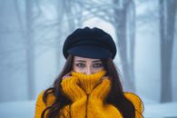 A Woman in Yellow Knitted Sweater and a Newsboy Cap
