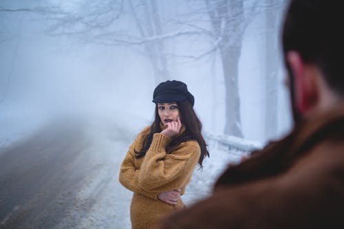 A Woman Wearing Knitted Sweater on a Snowy Weather