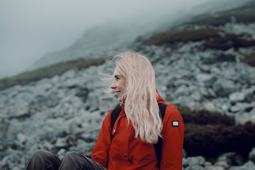 Woman in Red Jacket Sitting on Rock