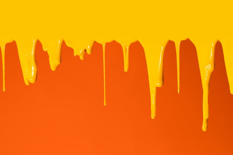 Yellow Paint Dripping On Orange Surface