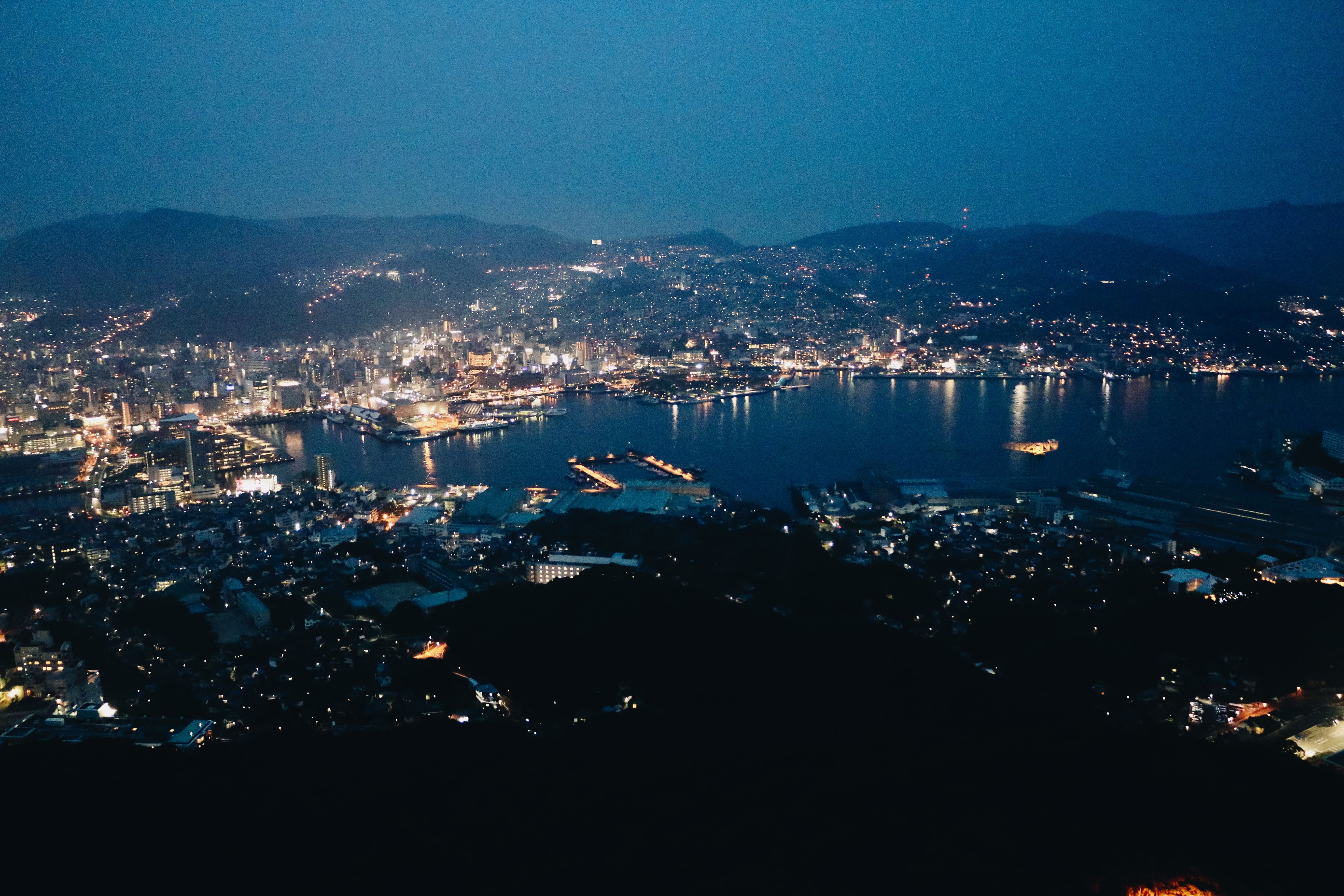 壮观的空中城市景观，在夜间展现出明亮的港口，尽显城市之美