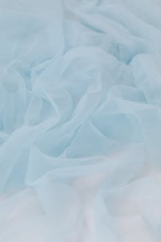 Soft pastel blue silk fabric creating an elegant and smooth texture, perfect for backgrounds or themes of softness and luxury.