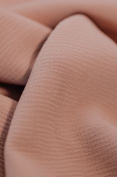 Detailed view of rippled beige fabric, showcasing texture and fabric design.