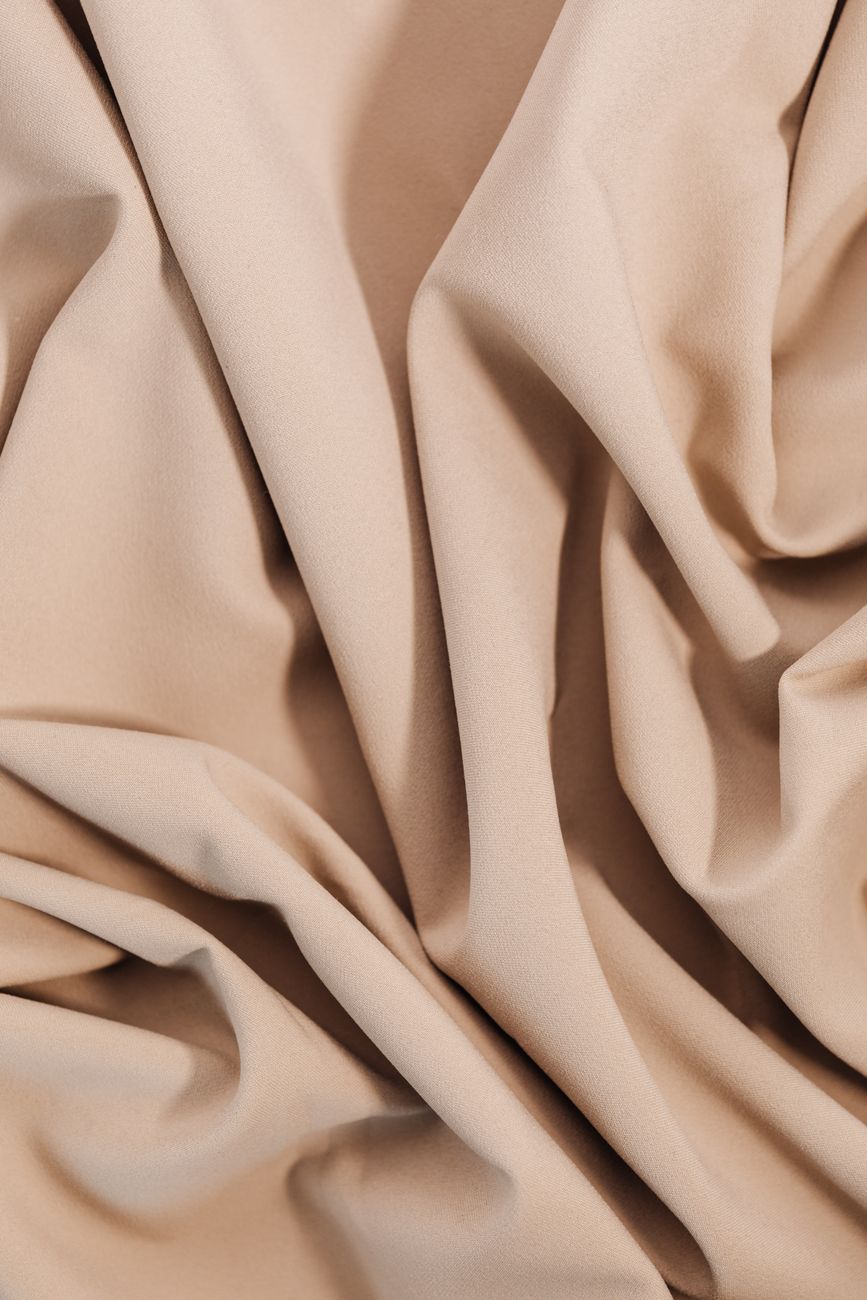 Close-up of beige cloth showcasing texture and folds, perfect for textile and design projects.