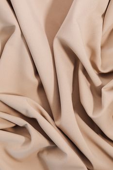 Close-up of beige cloth showcasing texture and folds, perfect for textile and design projects.