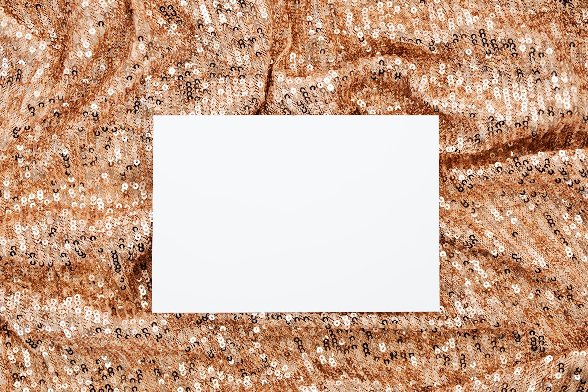 A blank card on a sparkling sequin background, ideal for mockups with a festive touch.