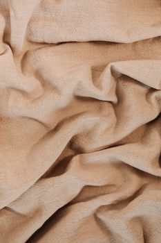 Detailed close-up of beige linen fabric showcasing its texture and folds.