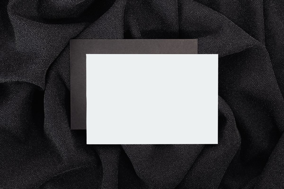 Blank embossed card on textured black cloth, by Kaboompics on Pexels