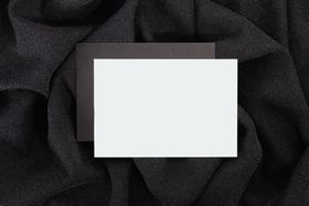 Blank card resting on textured black cloth — photo by Kaboompics on Pexels