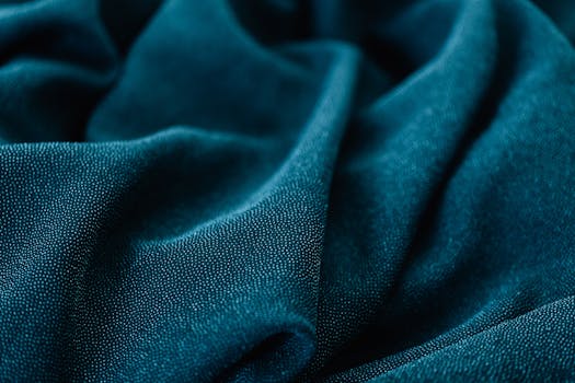 青色面料特写镜头，褶皱光滑，纹理与颜色清晰可见