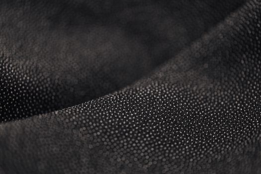 Macro shot of a black dotted fabric texture, showcasing intricate material details.