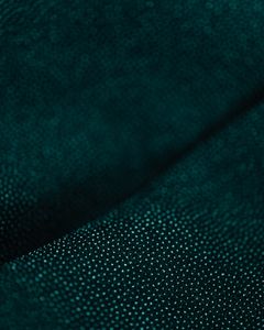 Detailed close-up of dark green fabric with a soft, textured pattern.