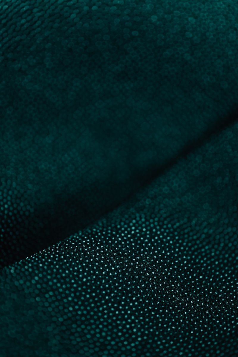Close-up of dark green perforated mesh fabric — photo by Kaboompics on Pexels