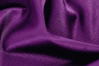 这是一张纹理光滑、褶皱优雅的浓郁紫色面料特写图像，非常适合用作纺织品或时尚背景