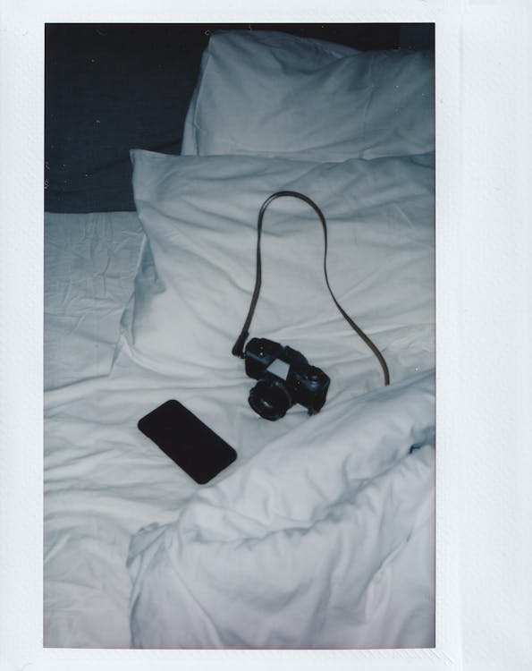 Free Bidikan Instan Kamera Dan Smartphone Di Tempat Tidur Putih Stock Photo