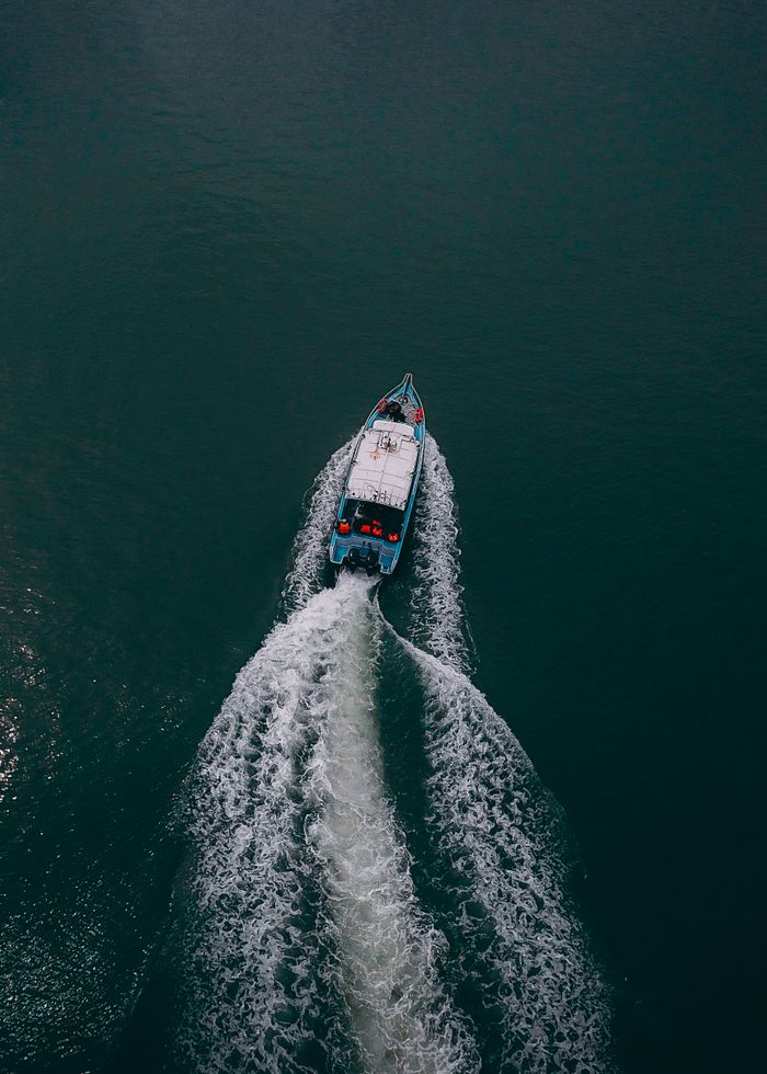 Motorboat throwing white spray across a deep blue sea