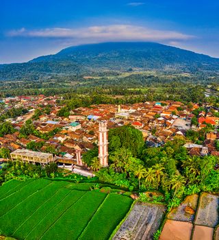 Scenic aerial view of vibrant farmland and town near a towering mountain in Banten, Indonesia. - Fotografer Sidoarjo