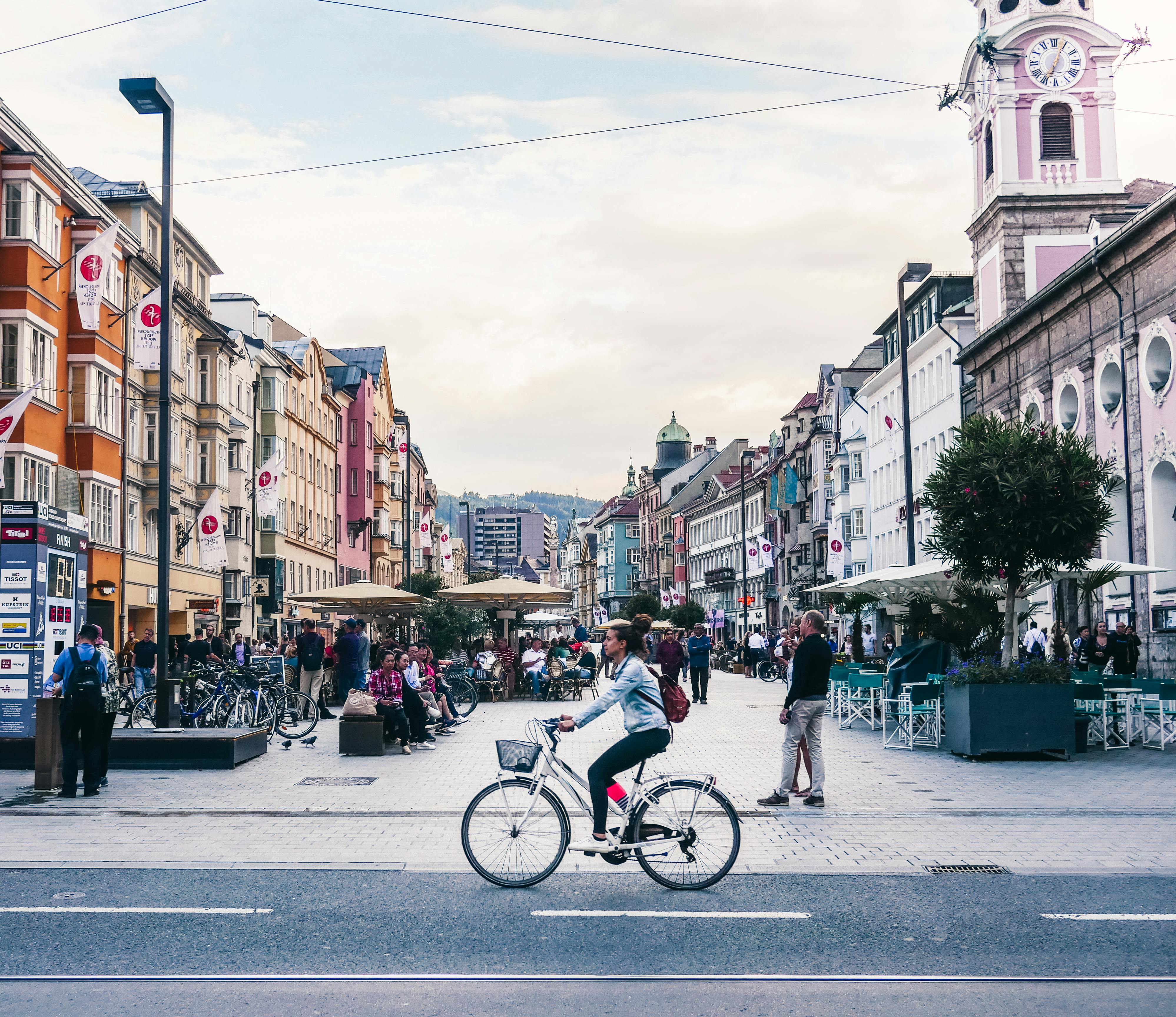 People Riding Bicycle on Road Near Buildings