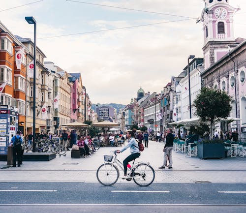 People Riding Bicycle on Road Near Buildings