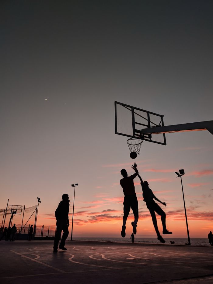 Players running shots at dusk — photo by Chbani Med on Pexels