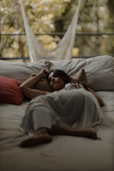 Woman relaxing on cozy bed outdoors, capturing tranquility amidst nature.