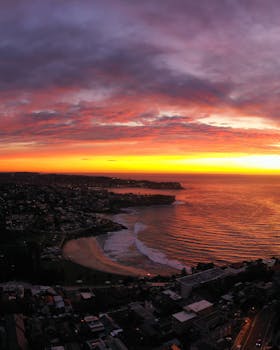 Captivating aerial view of Bronte, NSW at sunrise with vibrant skies over the ocean.