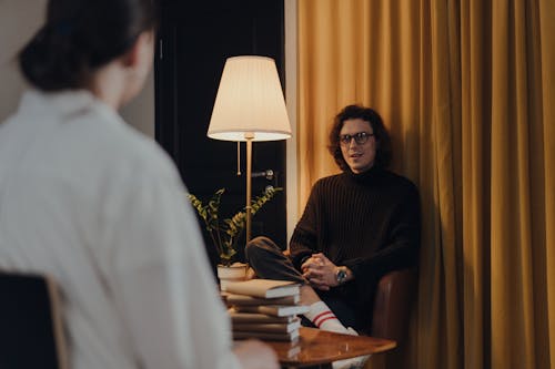 Vrouw In Zwart Shirt Met Lange Mouwen Zittend Op Een Stoel