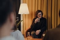 Man in Black Sweater Sitting on Chair