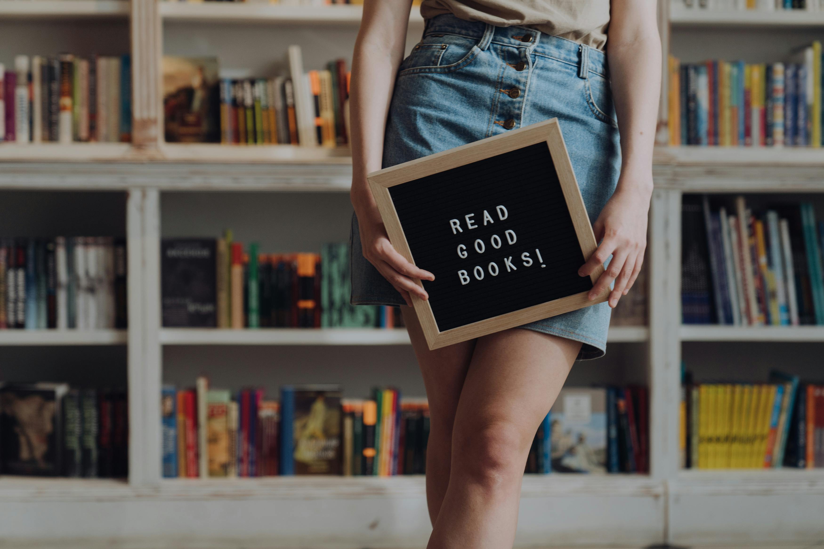 woman in blue denim shorts holding black ipad