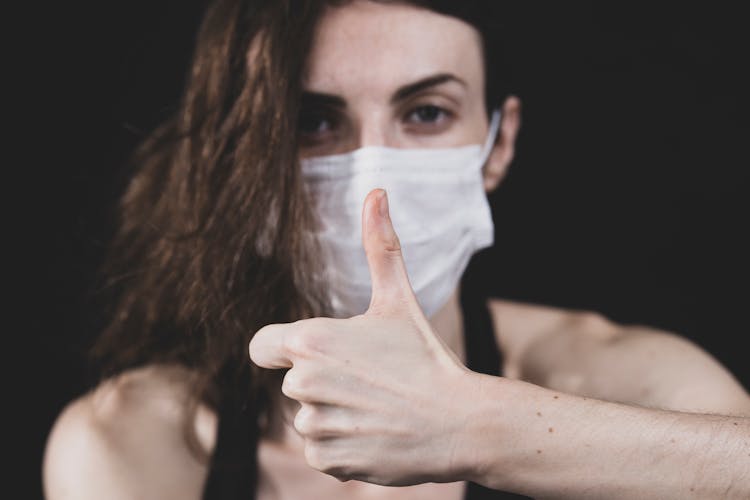 A Woman Wearing Face Mask Doing Thumbs Up